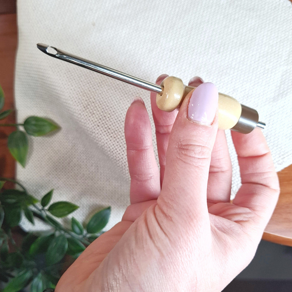 mano che sorregge il punch needle "Lavor" da 4 mm e fa vedere fino a che punto può essere regolato l'ago portandolo alla sua lunghezza massima