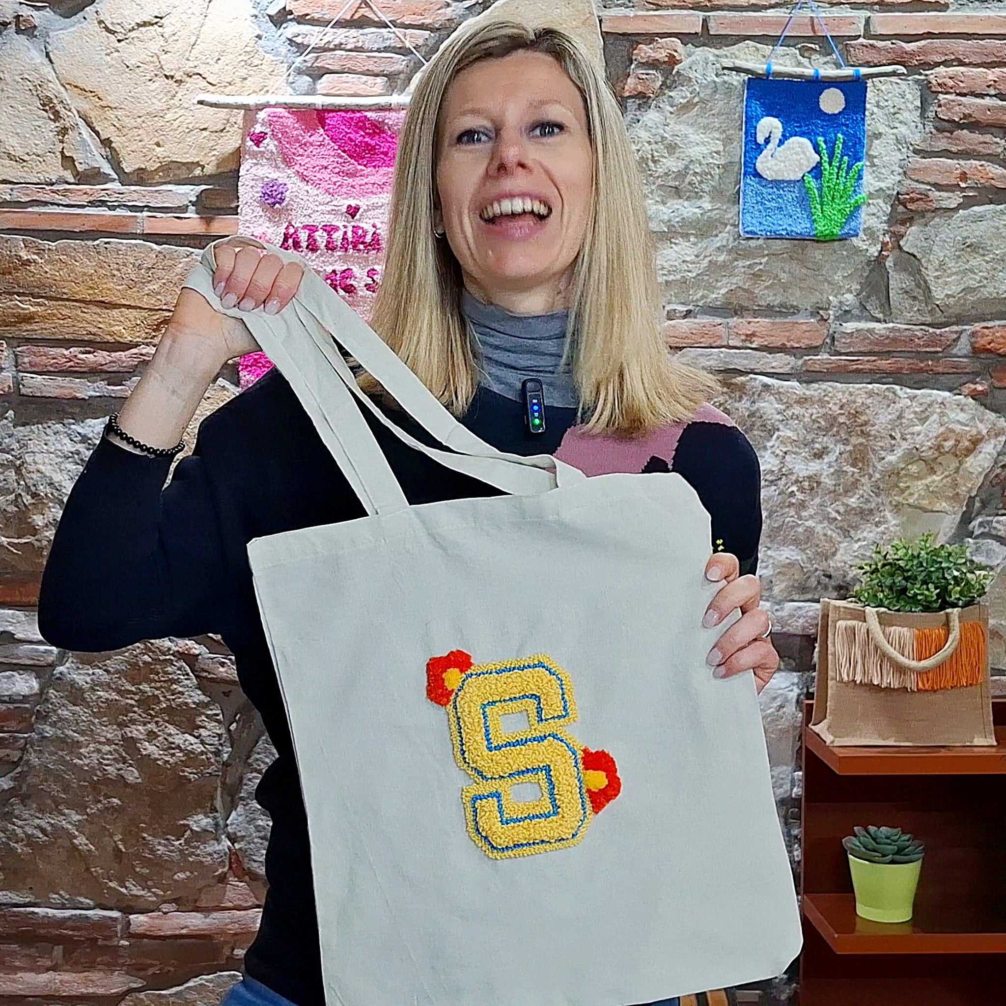 Silvia con in mano la shopper ricamata con il punch needle