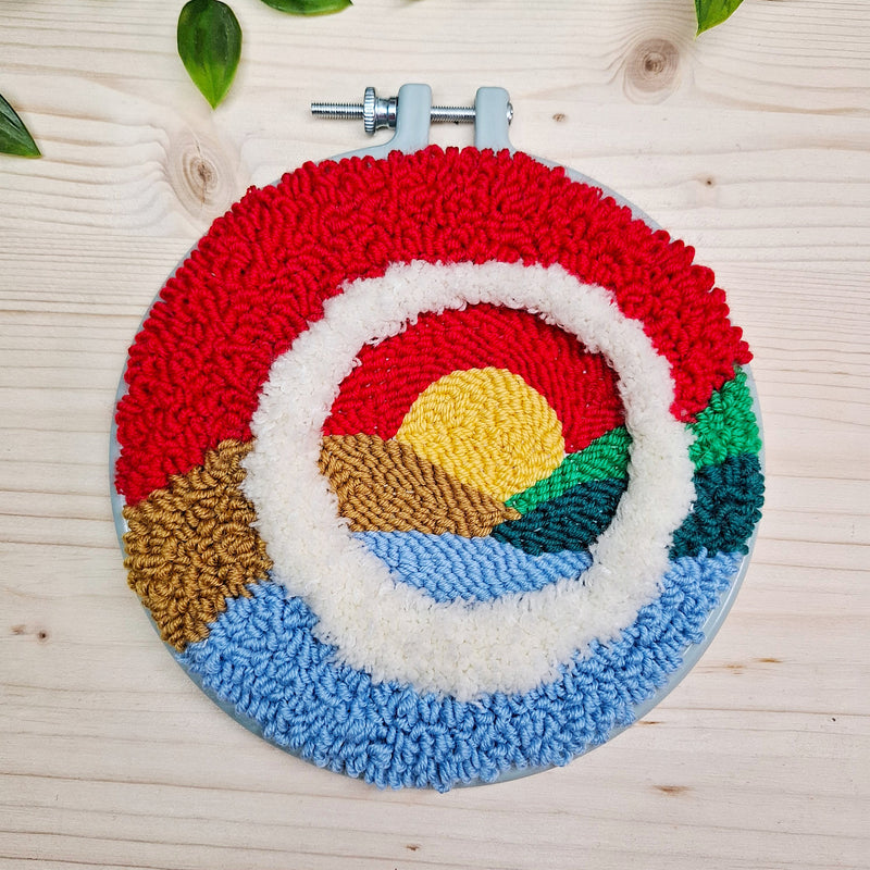 tramonto rosso su colline e lago realizzato con punch needle