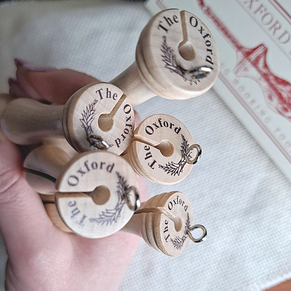 mani che tengono tutti e 5 gli Oxford punch needle Fine facendo vedere il marchio Oxford stampato sul retro