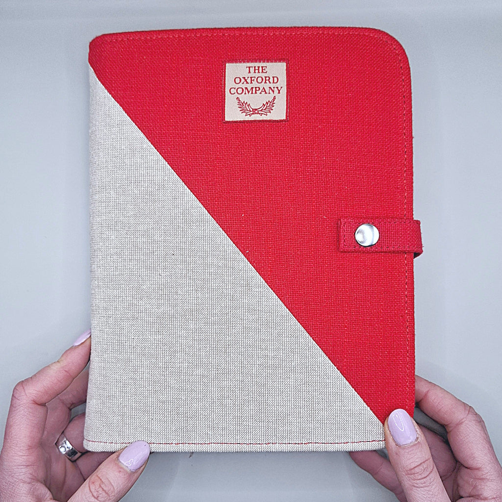 mani che sorreggono il cofanetto che è per metà rosso e per metà bianco panna, la divisione di colore è in diagonale, si vede il marchio The Oxford Company e un bottoncino a chiusura del cofanetto