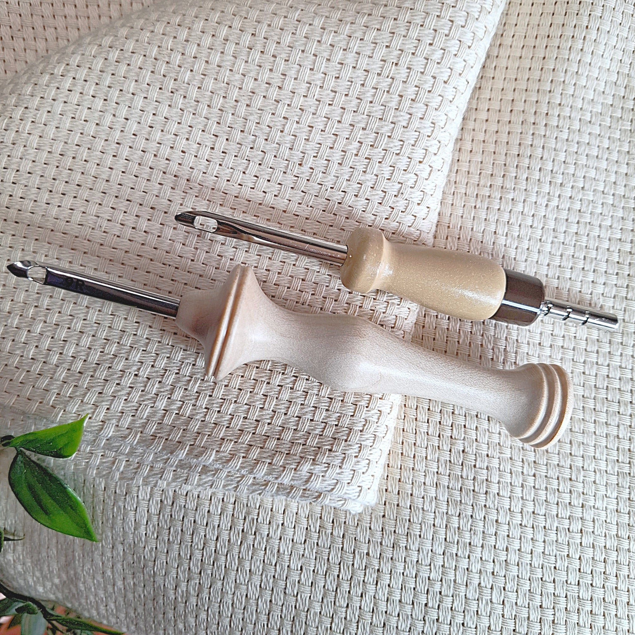 Due punch needle grossi (Lavor da 5,5 m e Oxford Punch Needle Regular) disposti sopra il tessuto per far capire quali sono gli aghi adatti