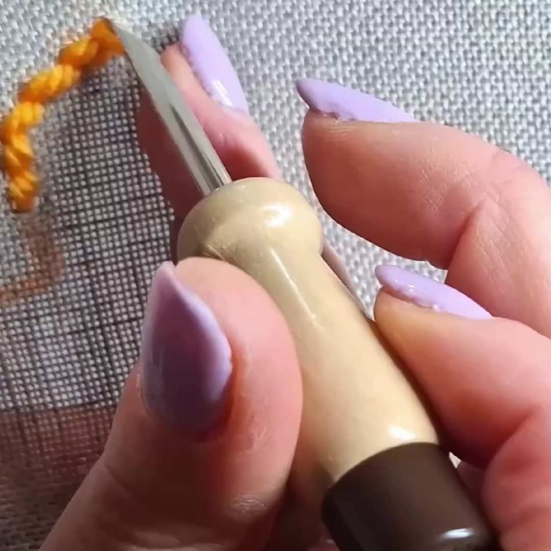 tessuto di lino per punch needle, si vede un punch needle di medio spessore che lo perfora senza problemi