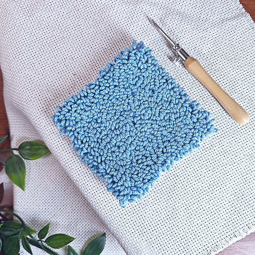 quadrato ricamato con un punch needle "Lavor" da 2,5 mm, si vede sia il quadrato con gli anellini creati da quel determinato spessore di ago, sia il punch needle con la punta da 2,5 mm montata