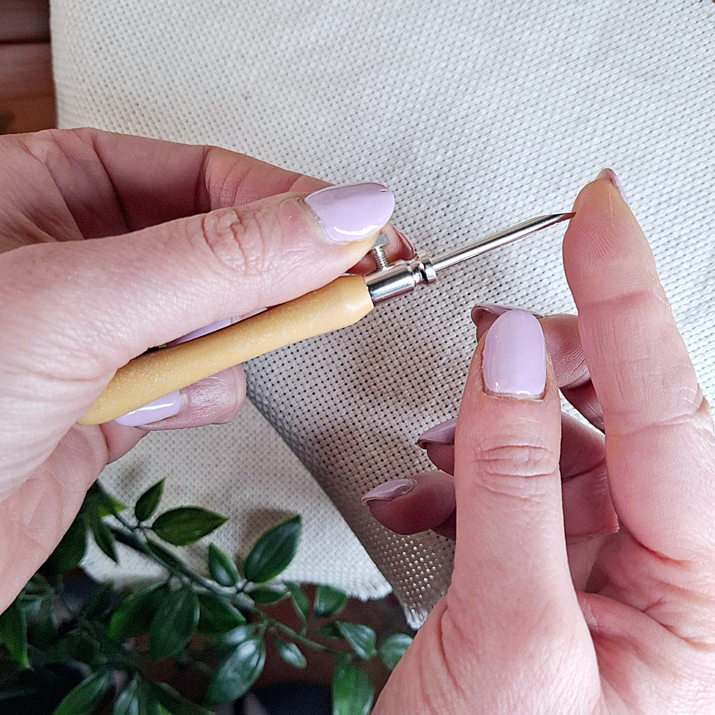 mani che tengono il punch needle "Lavor" con la punta da 3 mm inserita e lo fanno vedere da vicino